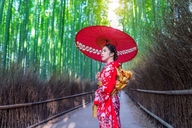 Bosque de bambú. Mujer asiática vistiendo un kimono tradicional japonés en el bosque de bambú en Kyoto, Japón.