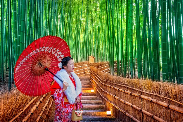 Bosque de bambú. Mujer asiática vistiendo un kimono tradicional japonés en el bosque de bambú en Kyoto, Japón.