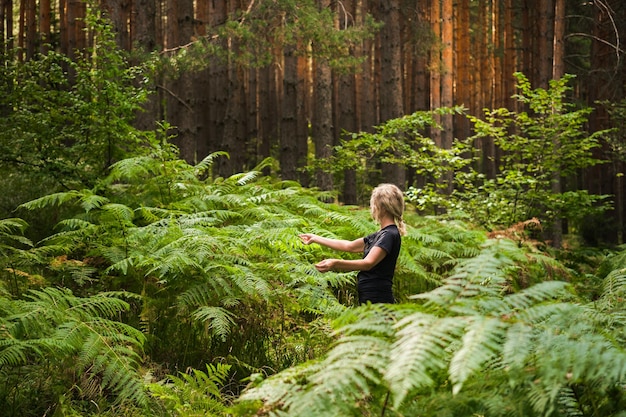 Foto gratuita el bosque baña a una mujer adulta en matorrales de helechos restaurando la salud y la psique en la naturaleza