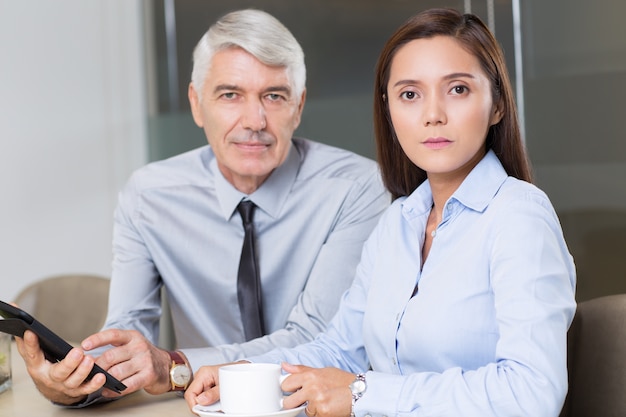 Foto gratuita boss y compañera de trabajo con la tableta en el café