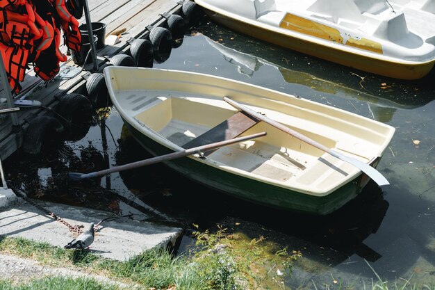 Bote pequeño atado a un muelle de madera en el lago