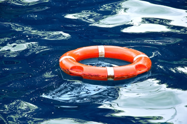 Bote salvavidas rojo en agua azul.