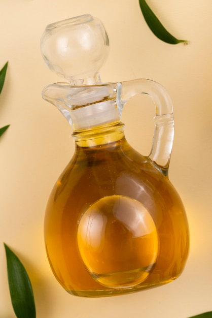 Foto gratuita botella de aceite de oliva fresco en la mesa