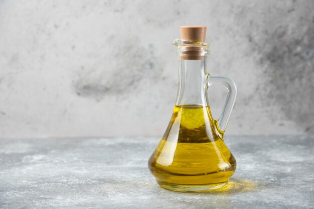 Botella de aceite de oliva sobre mesa de mármol.