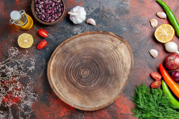 Foto gratuita botella de aceite de preparación de la cena frijoles limón y un montón de verde en la tabla de colores mezclados