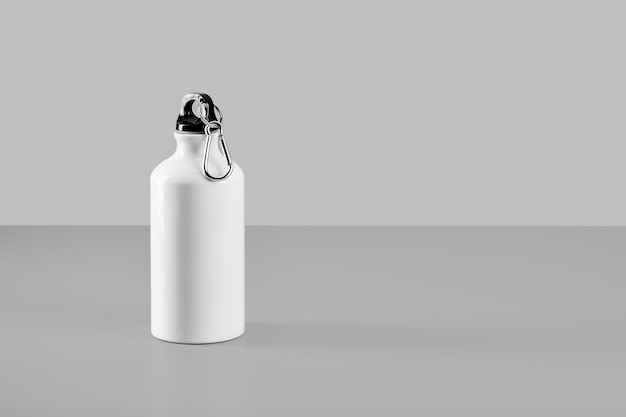 Botella de agua de aluminio blanco aislada sobre fondo gris claro con espacio para copiar texto. Minimalismo, reutilización y reciclaje de materiales
