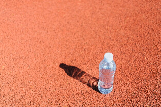 Botella de agua de plástico en la pista de atletismo