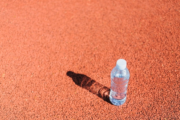 Botella de agua de plástico en la pista de atletismo
