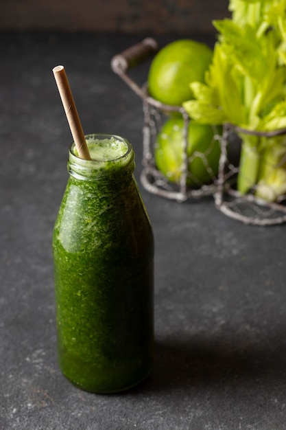 Foto gratuita botella de batido verde de ángulo alto