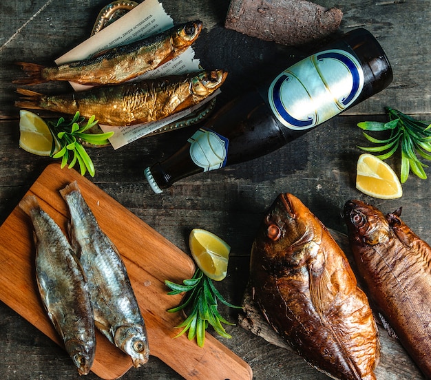 Botella de cerveza fría de pescado ahumado y limón en rodajas