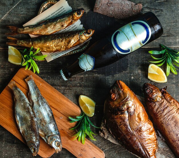 Botella de cerveza fría de pescado ahumado y limón en rodajas