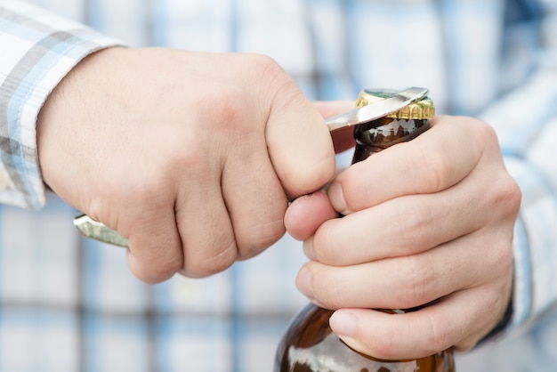 Botella de cerveza masculina de apertura irreconocible