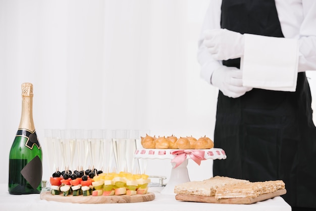 Foto gratuita botella de champagne con comida en una mesa