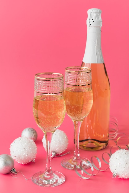 Foto gratuita botella de champagne con copas y bolas de navidad