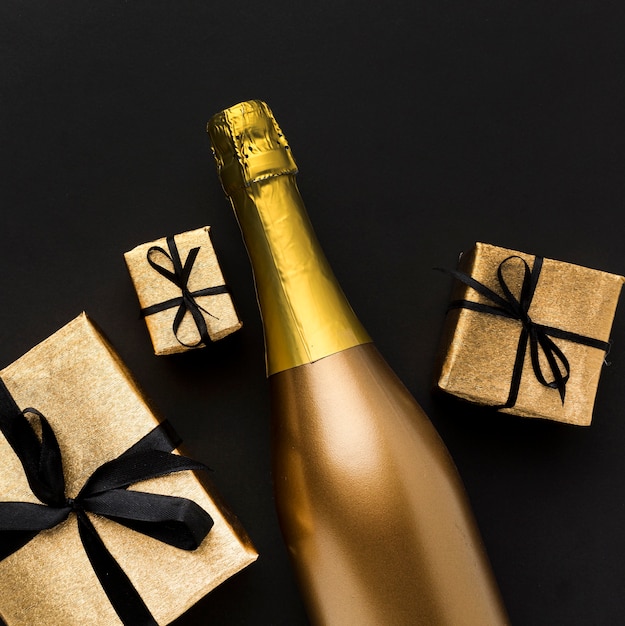 Foto gratuita botella de champagne con regalos