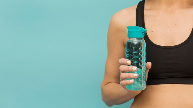 Botella de fitness llena de agua por mujer