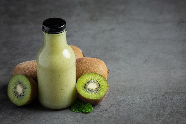 botella de jugo de kiwi en piso oscuro