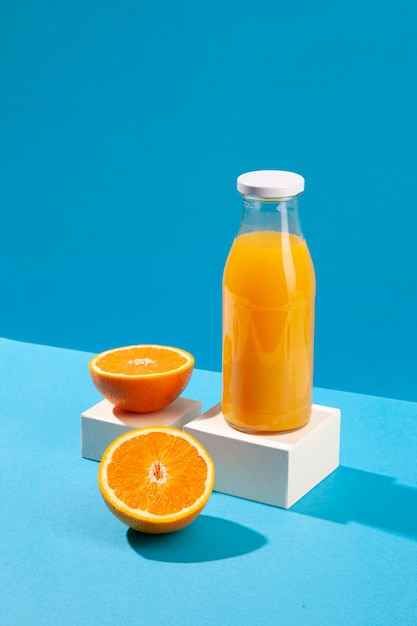 Foto gratuita botella de jugo de naranja de ángulo alto