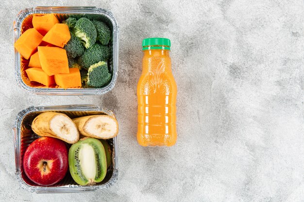 Botella de jugo de naranja con frutas y verduras en guisos