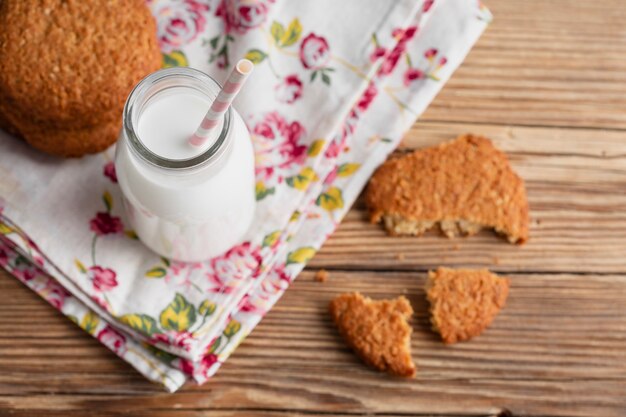 Foto gratuita botella de leche con paja y galletas.