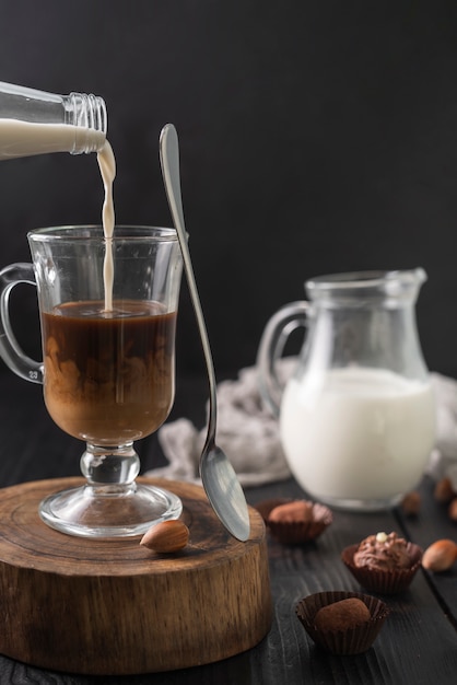 Botella de leche y taza de café con trufas.