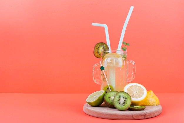 Botella de limonada con fruta cortada.