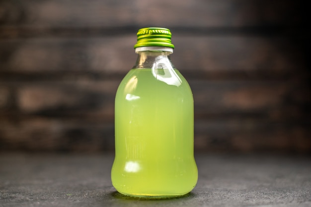 Foto gratuita botella de limonada vista frontal sobre superficie de madera