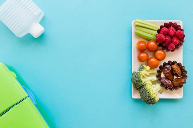 Botella y lonchera cerca de comida saludable