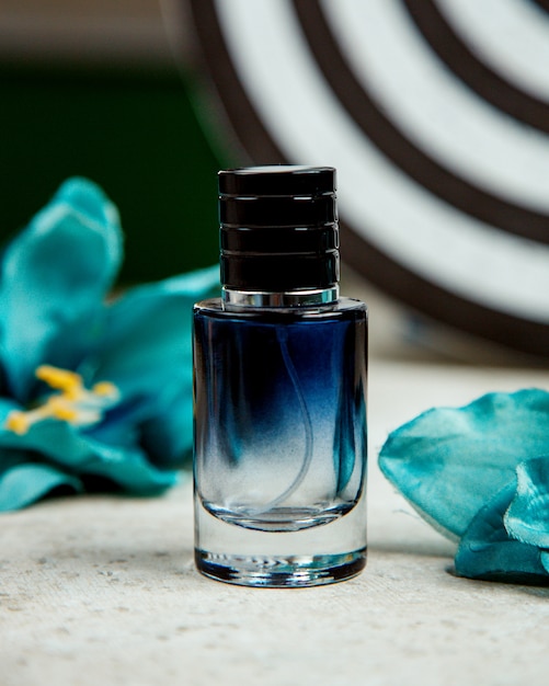 Foto gratuita botella negra de perfume sobre la mesa