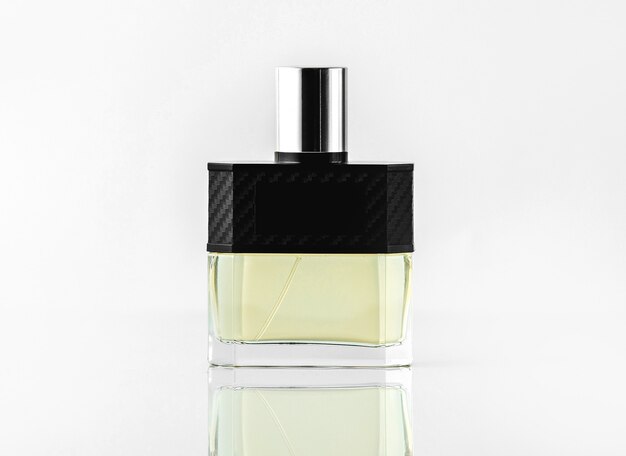 Una botella de perfume de vista frontal o perfume en colores diseñados en la pared blanca