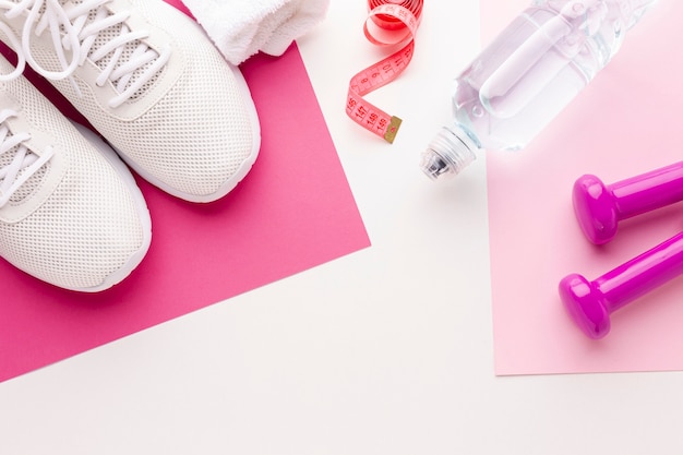 Foto gratuita botella de pesas de agua y zapatillas de deporte