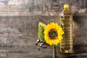 Foto gratuita botella de plástico de aceite de girasol sobre mesa de madera