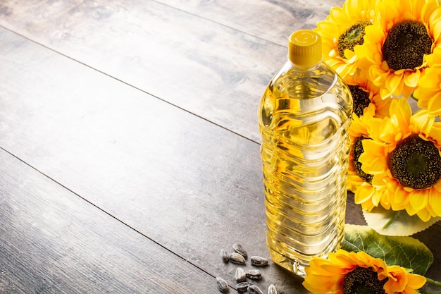 Foto gratuita botella de plástico de aceite de girasol sobre mesa de madera