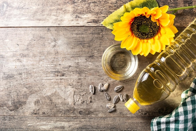 Botella de plástico de aceite de girasol sobre mesa de madera