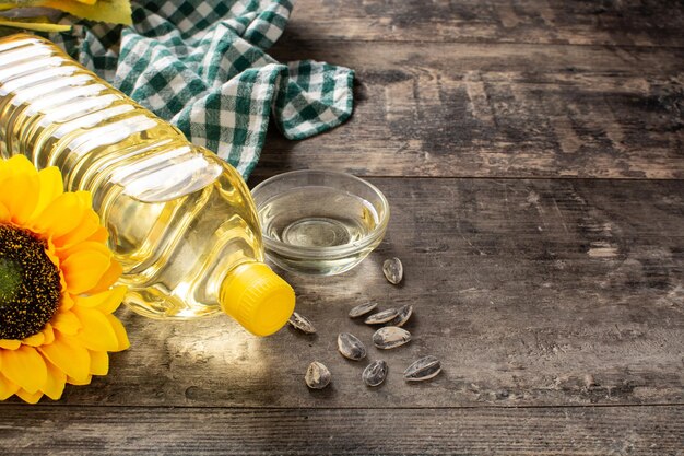 Botella de plástico de aceite de girasol sobre mesa de madera