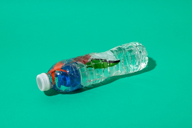 Botella de plástico de alto ángulo sobre fondo verde