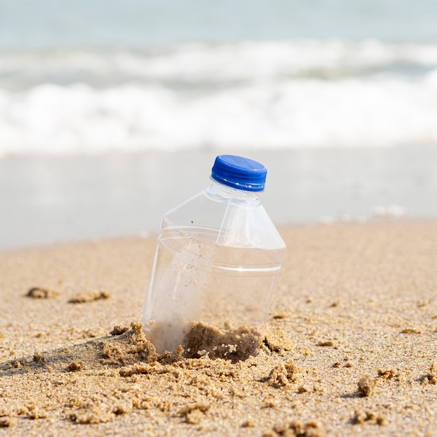 Foto gratuita botella de plástico dejada en la playa