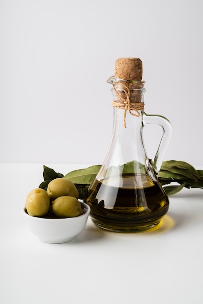 Botella de primer plano de aceite de oliva orgánico y aceitunas