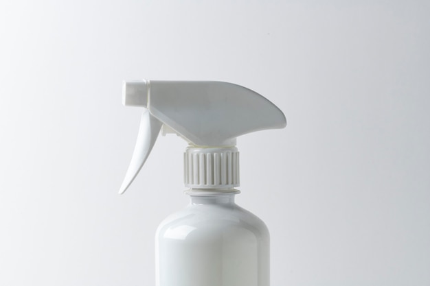 Botella de spray blanco sobre una superficie lisa