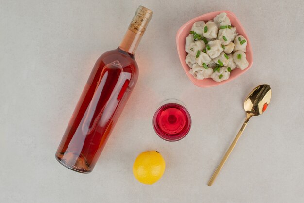 Botella con vaso de limonada y plato de albóndigas.