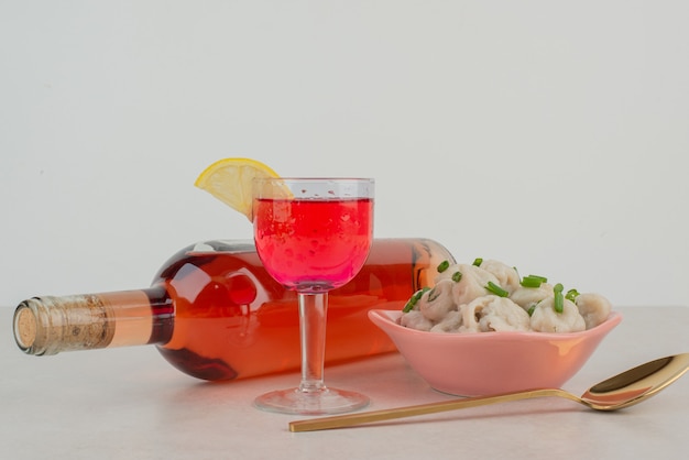 Botella con vaso de limonada y plato de albóndigas.