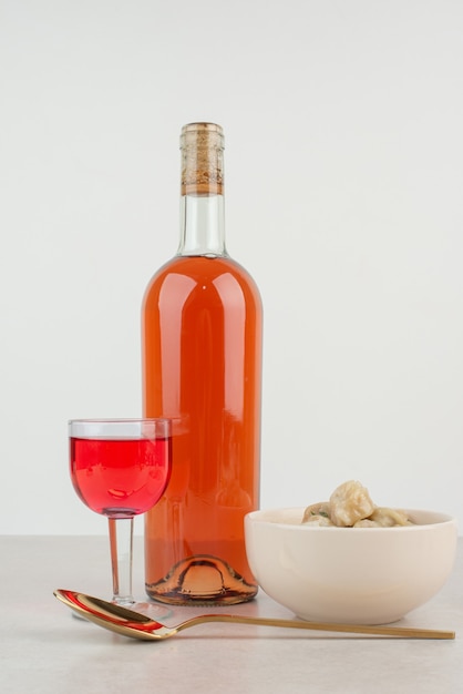 Botella con vaso de limonada y plato de albóndigas.