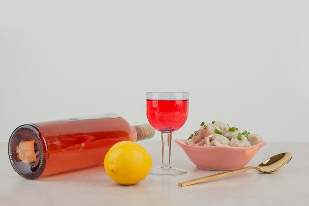 Botella con vaso de limonada y plato de albóndigas.