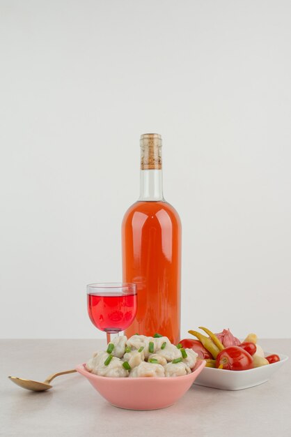 Botella con vaso de limonada y plato de albóndigas.