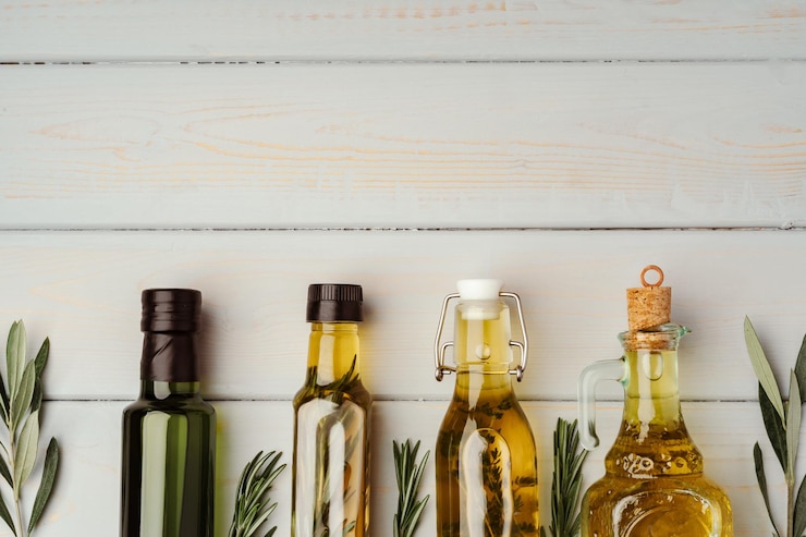 Foto gratuito botella de vidrio con aceite de oliva sobre un fondo gris