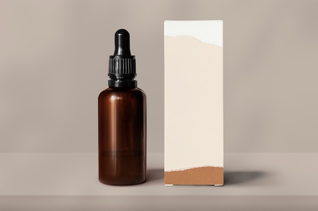 Botella de vidrio para el cuidado de la piel con caja de embalaje de productos de belleza.