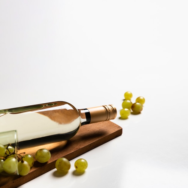Botella de vino blanco en tabla de cortar