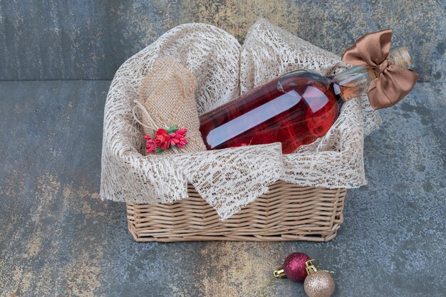 Botella de vino decorada con cinta en canasta de madera. Foto de alta calidad