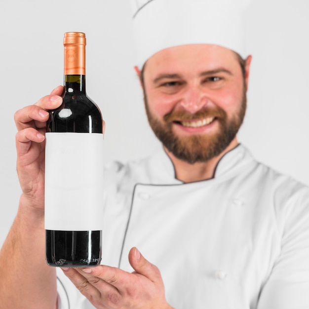 Botella de vino en manos del chef cocinero.
