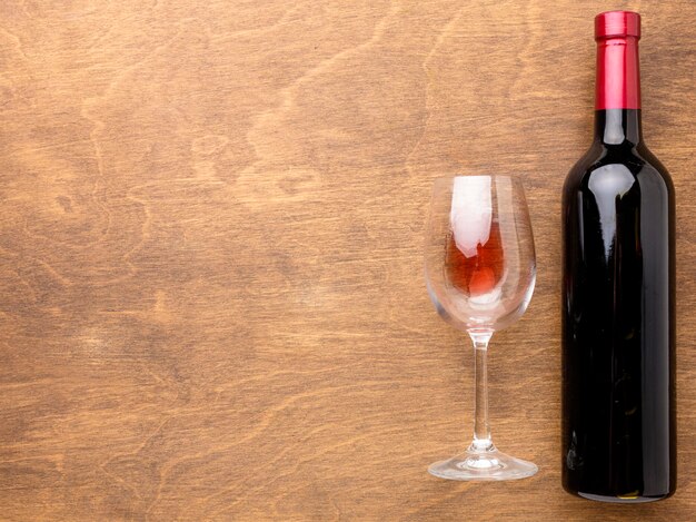 Botella de vino plana y vaso con espacio de copia